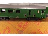 a green train car sitting on top of a cardboard box