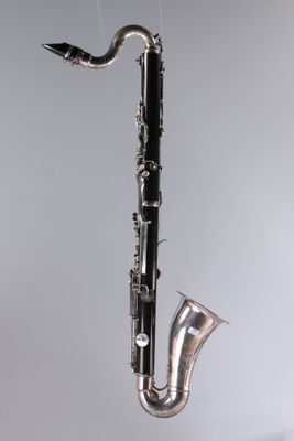 un gros plan d'un saxophone suspendu à un fil au mur