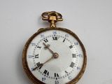 une montre de poche en or avec des chiffres romains sur le cadran