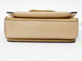 a tan leather purse with a gold chain hanging from the handle