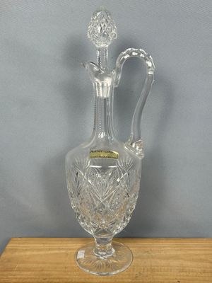 une image représentant un vase en verre transparent posé sur un socle en bois