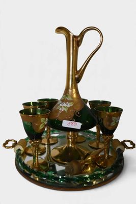 un vase et des tasses dorés et verts posés sur un plateau