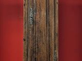 une grande horloge de parquet en bois devant un mur rouge