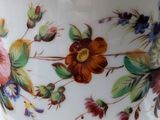 a white bowl with colorful flowers on it on a table