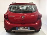 the rear end of a red car parked in a white room