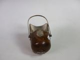 a small metal vase with a wooden handle on a white surface