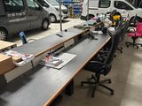 une longue table au milieu d'une pièce, avec une camionnette en arrière-plan