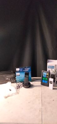 une table sur laquelle se trouvent un ordinateur portable, un téléphone portable et d'autres appareils électroniques