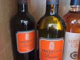 plusieurs bouteilles de vin sont alignées sur une étagère en bois