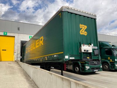 two semi trucks that are parked in front of a building