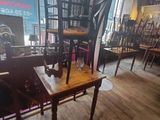 tables and chairs in a room with a large window in the background