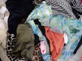 a pile of clothes sitting on the floor next to a pile of clothes
