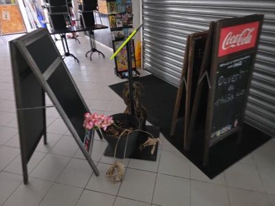 un panneau posé par terre à côté d'un tableau noir