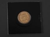 a coin with a picture of a man on it on a black surface