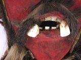 a close up of a red mask with white teeth