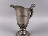 a silver cup with a spoon in it on a table