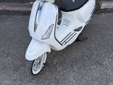 un scooter blanc garé devant un immeuble