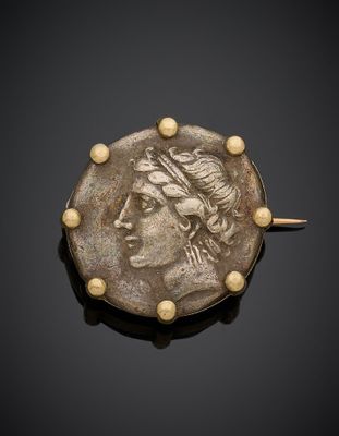 une broche romaine antique en forme de pièce de monnaie, ornée de perles