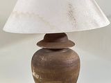 une lampe posée sur une table, munie d'un abat-jour blanc