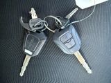 two keys attached to a car key holder on a car seat