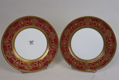 deux assiettes rouges et dorées, ornées de motifs dorés sur fond blanc