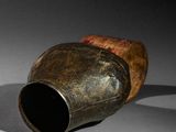 a brown vase sitting on a table with a black background