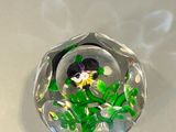 a small glass object with a flower inside of it