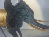 a statue of an elephant with a gold tusk on it ' s head