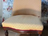 a chair that is sitting in front of a wallpapered wall