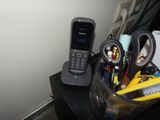 a cell phone sitting on top of a desk next to a pile of office supplies