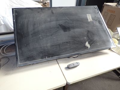 a blackboard sitting on top of a desk next to a remote control