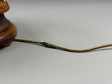 une lampe ancienne en bois à laquelle est attaché un fil métallique
