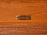 a close up of a wooden box with a name plate