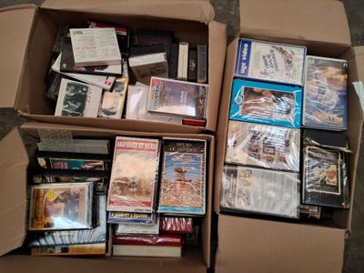 un grand nombre de DVD dans une boîte en carton posée sur le sol