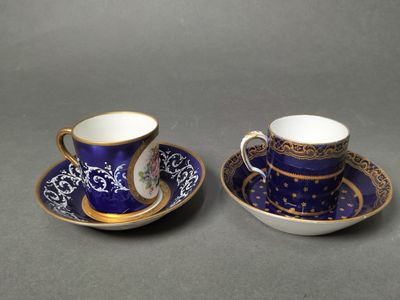 two cups and saucers with blue and gold designs on them