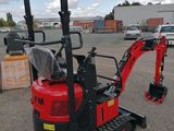 a red mini excavator parked in a parking lot