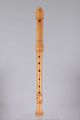 a wooden flute on a stand on a white surface
