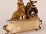 a statue of a woman sitting on top of a clock
