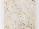 a square marble cutting board with gold crosses on a white background