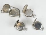 four silver pocket watches with chain on a white surface