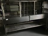 a kitchen with a metal counter and a metal shelf