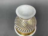 a white and gold vase and a pair of scissors