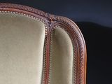 the back of a chair with a wooden frame and beige upholstered upholstered seat