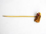 an image of a gold stick with a pink stone in the middle