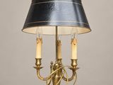 une lampe de table en laiton avec un abat-jour noir et deux bougies