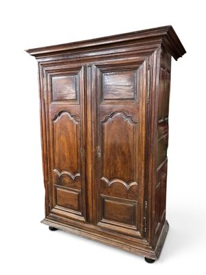 une vieille armoire en bois à deux portes et deux tiroirs