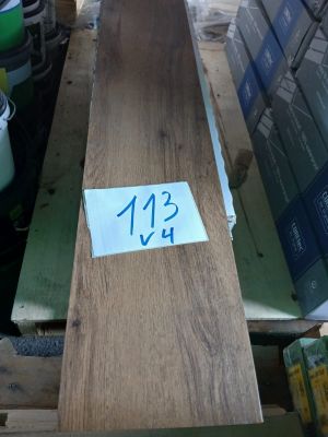 une longue table en bois sur laquelle est posée une étiquette de prix