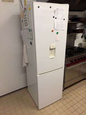 a white refrigerator in a kitchen with a stove and oven