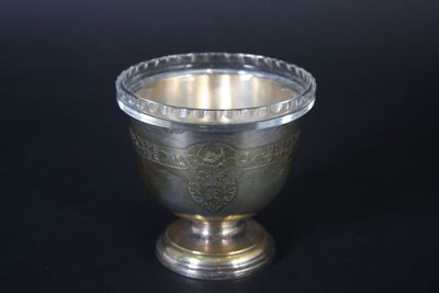 a silver cup on a black table with a black background