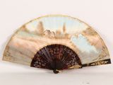 a fan with a painting on it sitting on a table